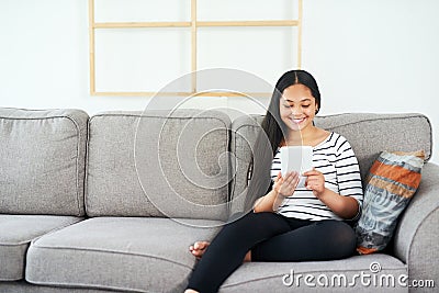 Child, tablet and sofa at home with elearning, online education and upskill app game. Living room, tech and digital Stock Photo
