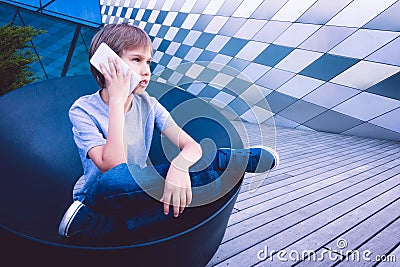 Child talking on cell phone in the street Stock Photo