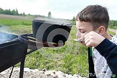 Child tastes russian fish soup Stock Photo
