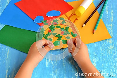 Child tearing colored paper into pieces. Home activity to improve fine motor skill development. Baby play. How to work with paper Stock Photo