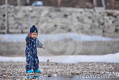 a child throws stones into the water Stock Photo