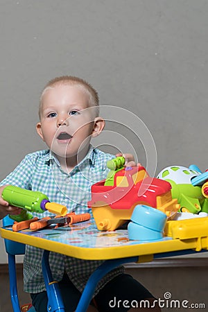 A child with toy pliers and drill repairs cars Stock Photo