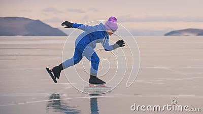 The child train on ice professional speed skating. The girl skates in the winter in sportswear, sport glasses, suit Stock Photo