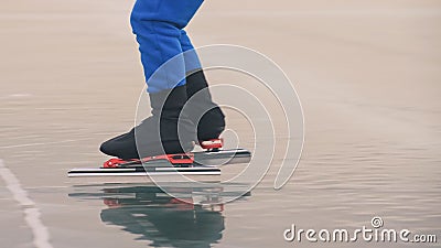 The child train on ice speed skating. The legs in skates close up. The kid girl skates in the winter in sportswear sport Stock Photo