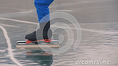 The child train on ice speed skating. The legs in skates close up. The kid girl skates in the winter in sportswear sport Stock Photo