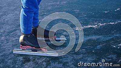 The child train on ice speed skating. The legs in skates close up. The kid girl skates in the winter in sportswear sport Stock Photo