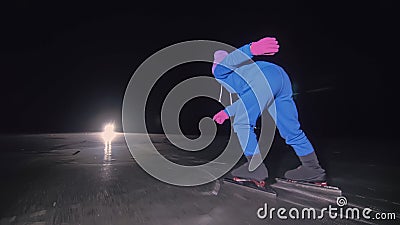 The child train on ice speed skating. The night skating. The girl skates in the winter in sportswear, sport glasses Stock Photo