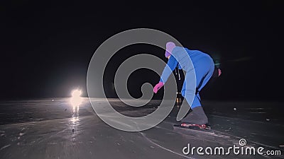 The child train on ice speed skating. The night skating. The girl skates in the winter in sportswear, sport glasses Stock Photo