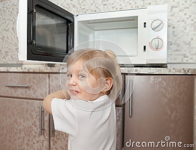 Child trying to turn on microwave Stock Photo