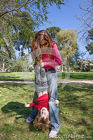 Child upside down hanging from mother hands Stock Photo