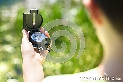 Child using a compass for navigation by a lake Stock Photo
