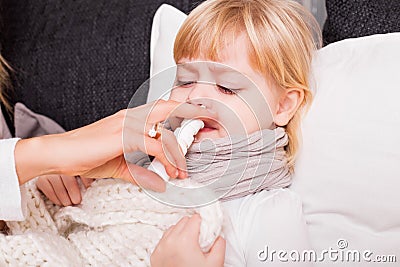 Child using medicine to treat cold Stock Photo