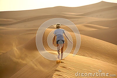 Child walking away on a sand dune Stock Photo