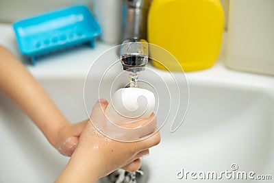 A child washes his hands with a bar of soap u to prevent coronovirus Stock Photo