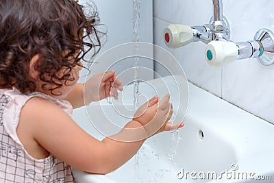 Child washing hand with water.To keep the flu virus at bay, wash your hands with soap and water several times a day. Stock Photo