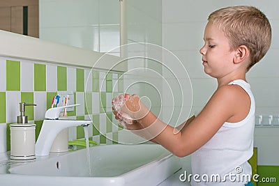 Child washing hands with soap in the bathroom. Stock Photo