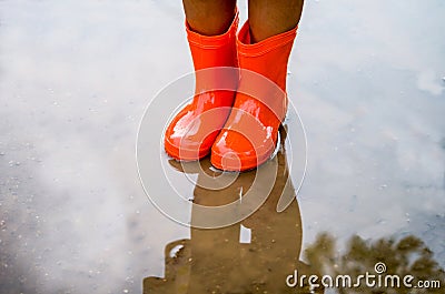 Child wearing orange rain boots Stock Photo