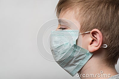 Child wears medical mask to protect from germs. Portrait Side view Stock Photo