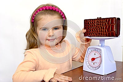 The child weighs a purse with money Stock Photo