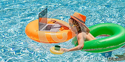 Child working on laptop from the swimming pool. Summer business. Stock Photo