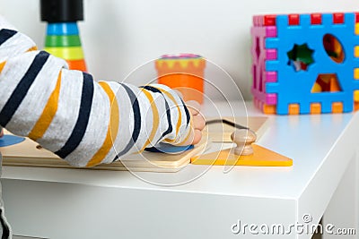 Child works with Montessori material for fine motor skills, sensory play. Playing children with geometry figures Stock Photo