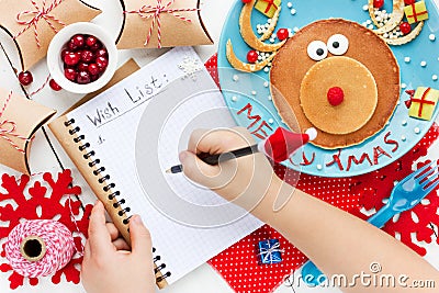 Child writes letter for santa, wish list to Christmas on table w Stock Photo