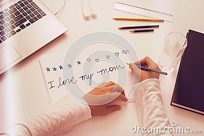 Child writes a Mothers Day message. Stock Photo