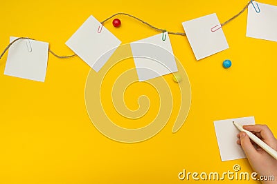 Child writes a note on a yellow background. The paper notes Stock Photo