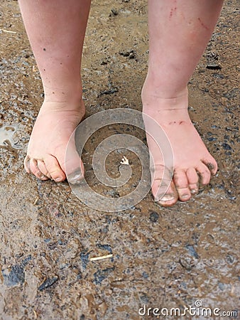 A child muddy feet from spashing in puddles after rain Stock Photo