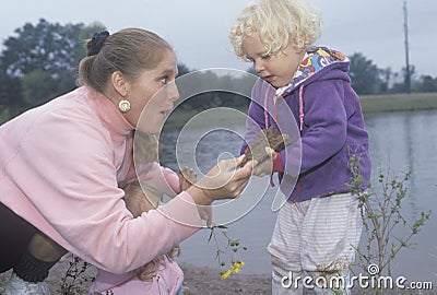 A childcare worker playing with children by a lake, Washington D.C. Editorial Stock Photo