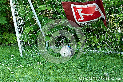 childerns soccer goal with ball and sign of German league. ball in the goal, green meadow Editorial Stock Photo