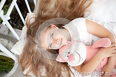 Childhood concept. The child gently hugs the toy. Hugs, Love and Tenderness. A large portrait of the face of a little girl with lo Stock Photo