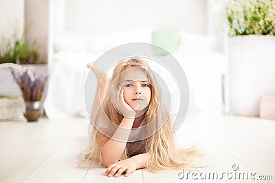 Childhood concept. The child plays in the children`s room. Little blonde girl in pajamas at home. time for sleep and rest. Baby gi Stock Photo