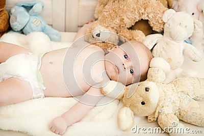 Childhood and curiosity concept. Baby boy with his soft toys Stock Photo