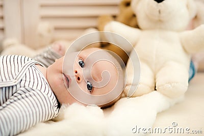 Childhood and curiosity concept. Baby boy in striped bodysuit Stock Photo