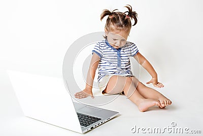 Childhood in digital age. Attractive little kid sneezes and has eyes shut, looks down, sits near portable laptop computer, isolate Stock Photo