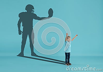 Childhood and dream about big and famous future. Conceptual image with boy and shadow of american football player on Stock Photo