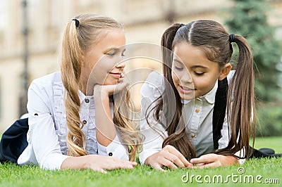 Childhood friends. Happy children relax on green grass. Happy childhood. Enjoying childhood years. Childhood protection Stock Photo