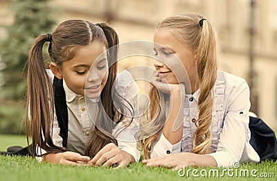 Childhood friends. Happy children relax on green grass. Happy childhood. Enjoying childhood years. Childhood protection Stock Photo