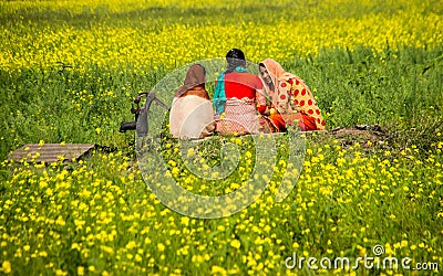 Childhood friends are passing leisure time in the mustard field Editorial Stock Photo