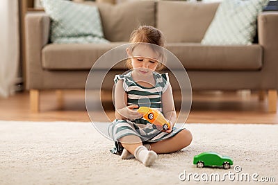 Happy baby girl playing with toy car at home Stock Photo