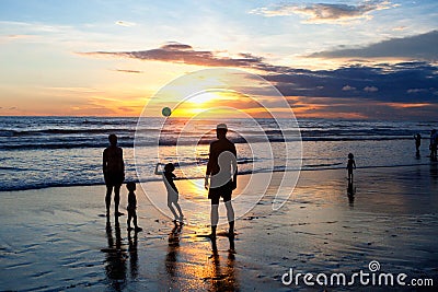 Children and adults play ball on the beach during sunset Editorial Stock Photo