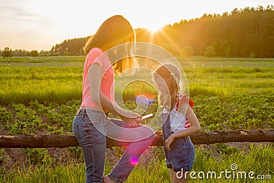 Hildren in the background of nature play with a smartphone. Stock Photo