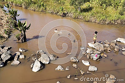 Children bathe in the muddy river, Madagascar Editorial Stock Photo