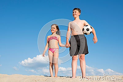 Children on the beach play with a ball. Holidays, rest. Sports and active lifestyle concept Stock Photo