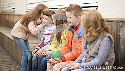 Children on a bench playing Chinese whispers Stock Photo