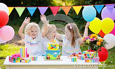 Children blow candles on birthday cake. Kids party Stock Photo