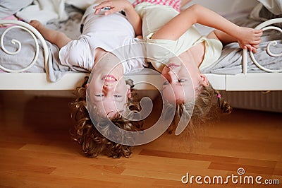The children, boy and girl, naughty on the bed in the bedroom. Stock Photo