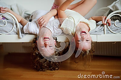 The children, boy and girl, naughty on the bed in the bedroom. Stock Photo