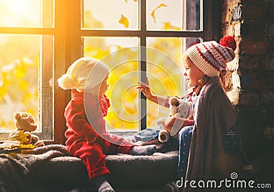 Children brother and sister admiring window for autumn Stock Photo